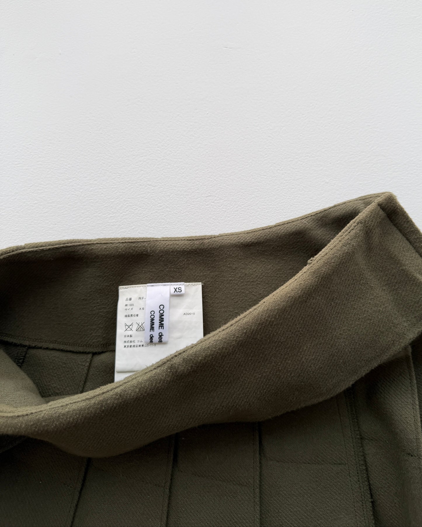 View of label on Comme des Garçon pleated skirt