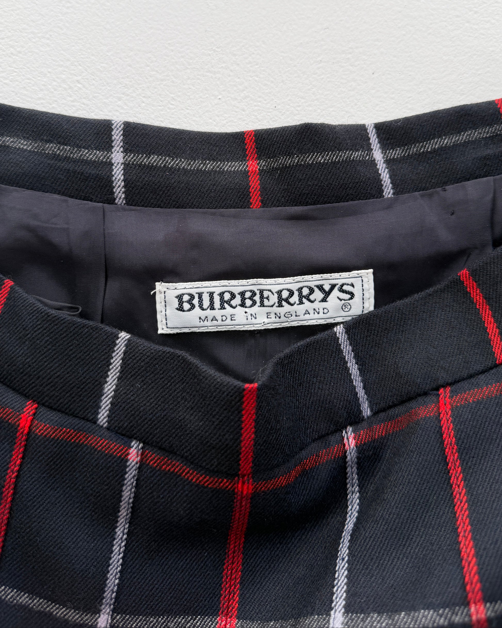 Close-up of a Burberry label on a plaid skirt with red and white lines