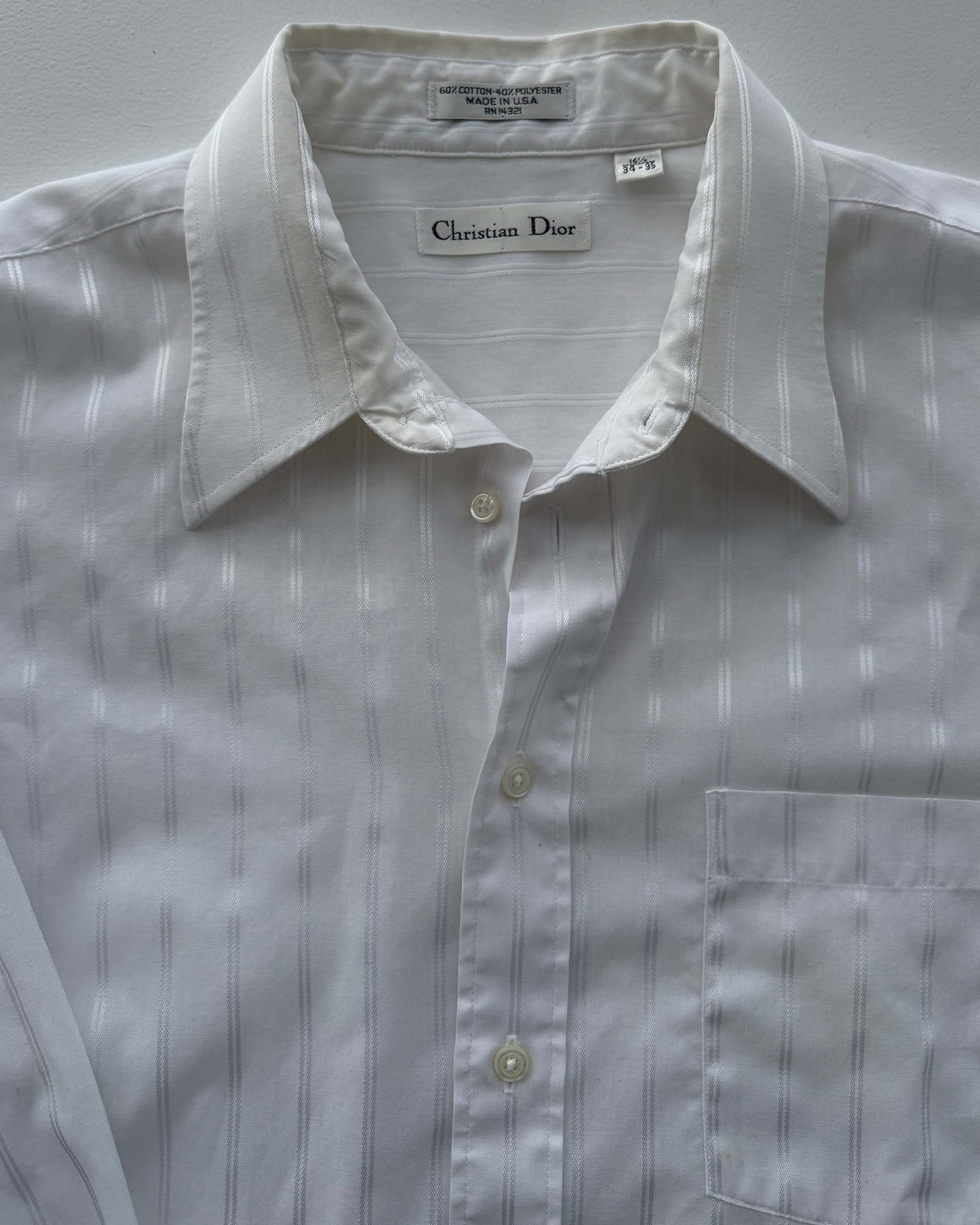 Christian Dior label on white striped button up shirt