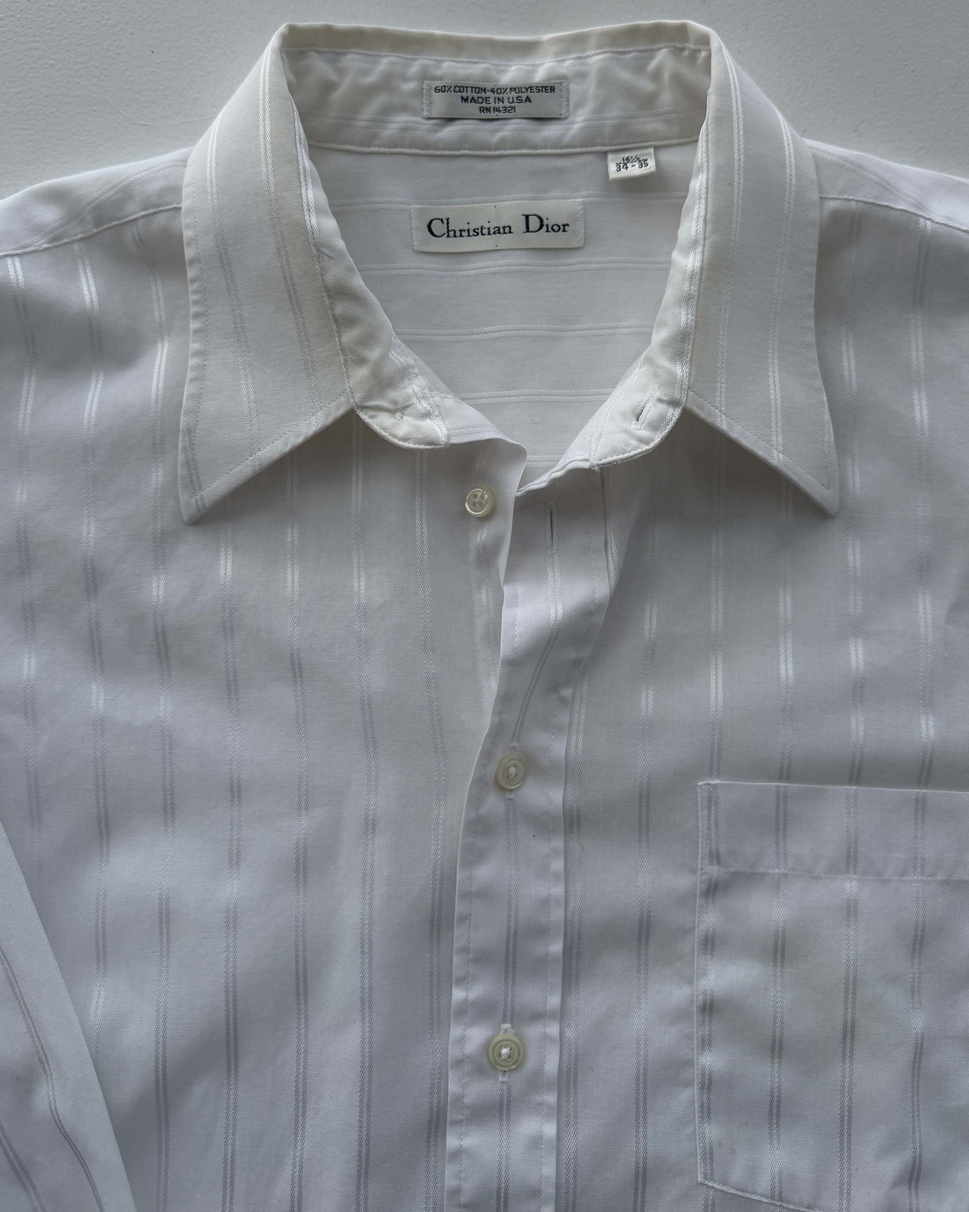 Christian Dior label on white striped button up shirt