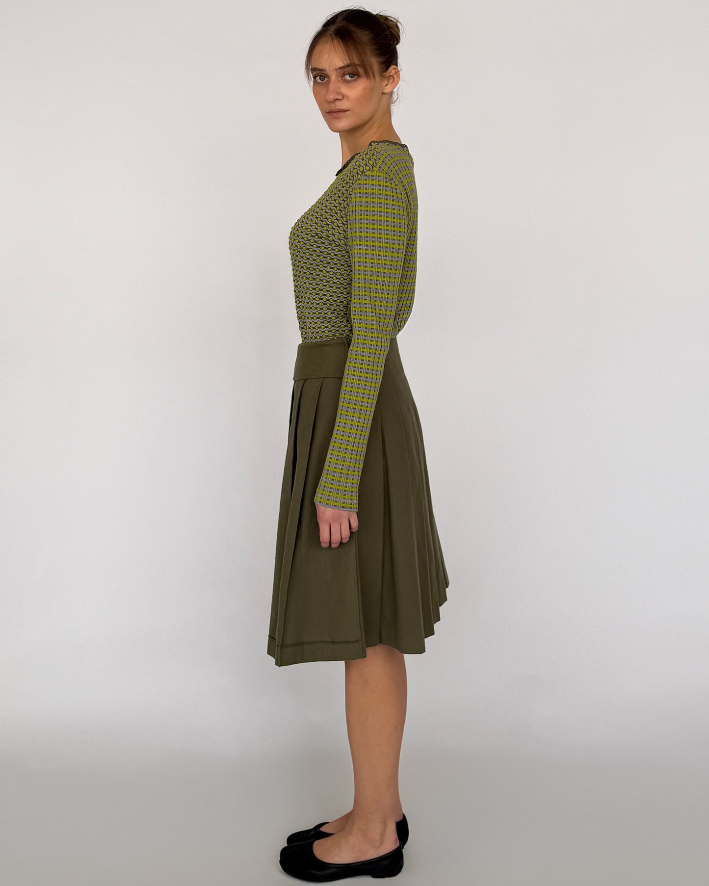 Side view of Comme des Garçon green pleated midi skirt
