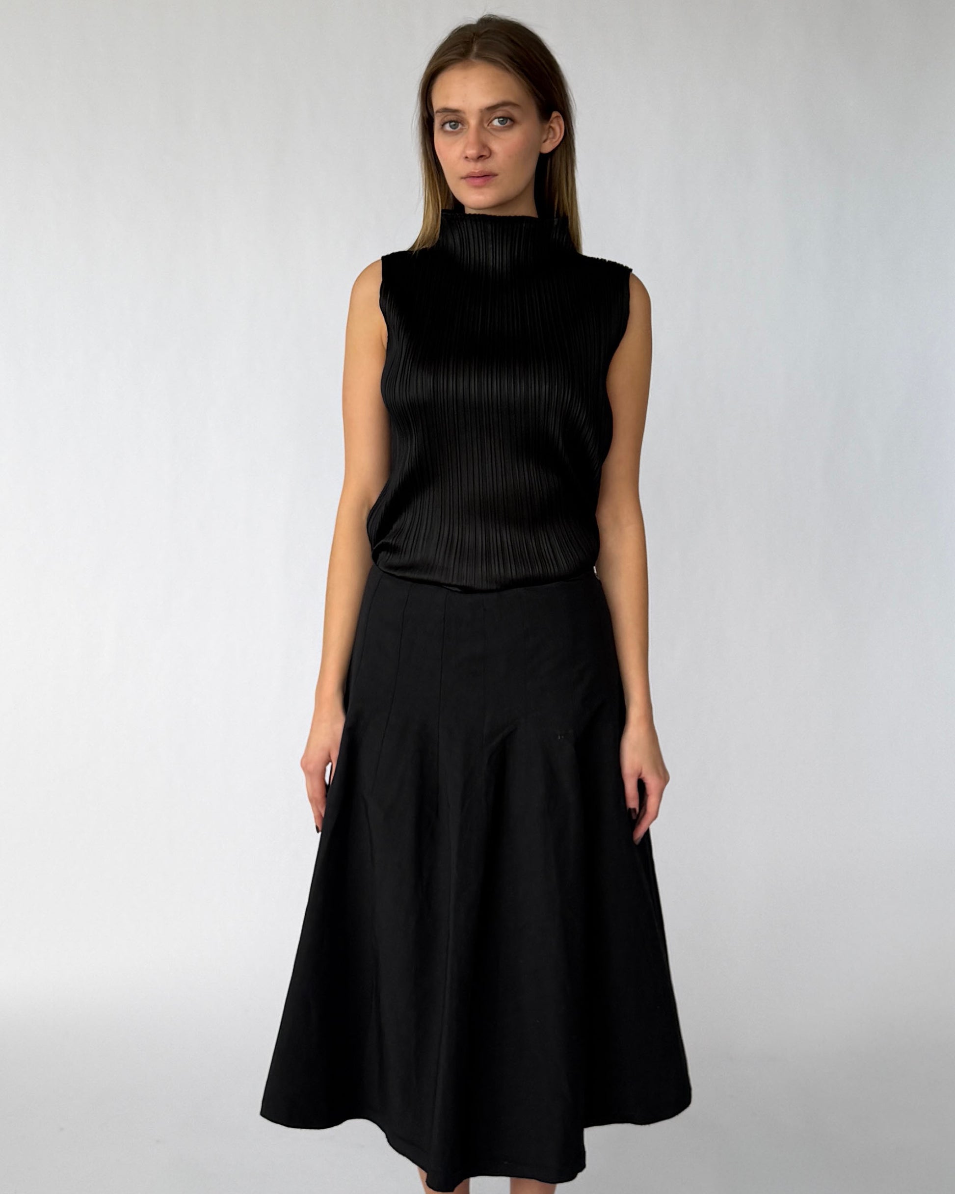 Issey Miyake Pleats Please black sleeveless blouse with mock-neck worn on model