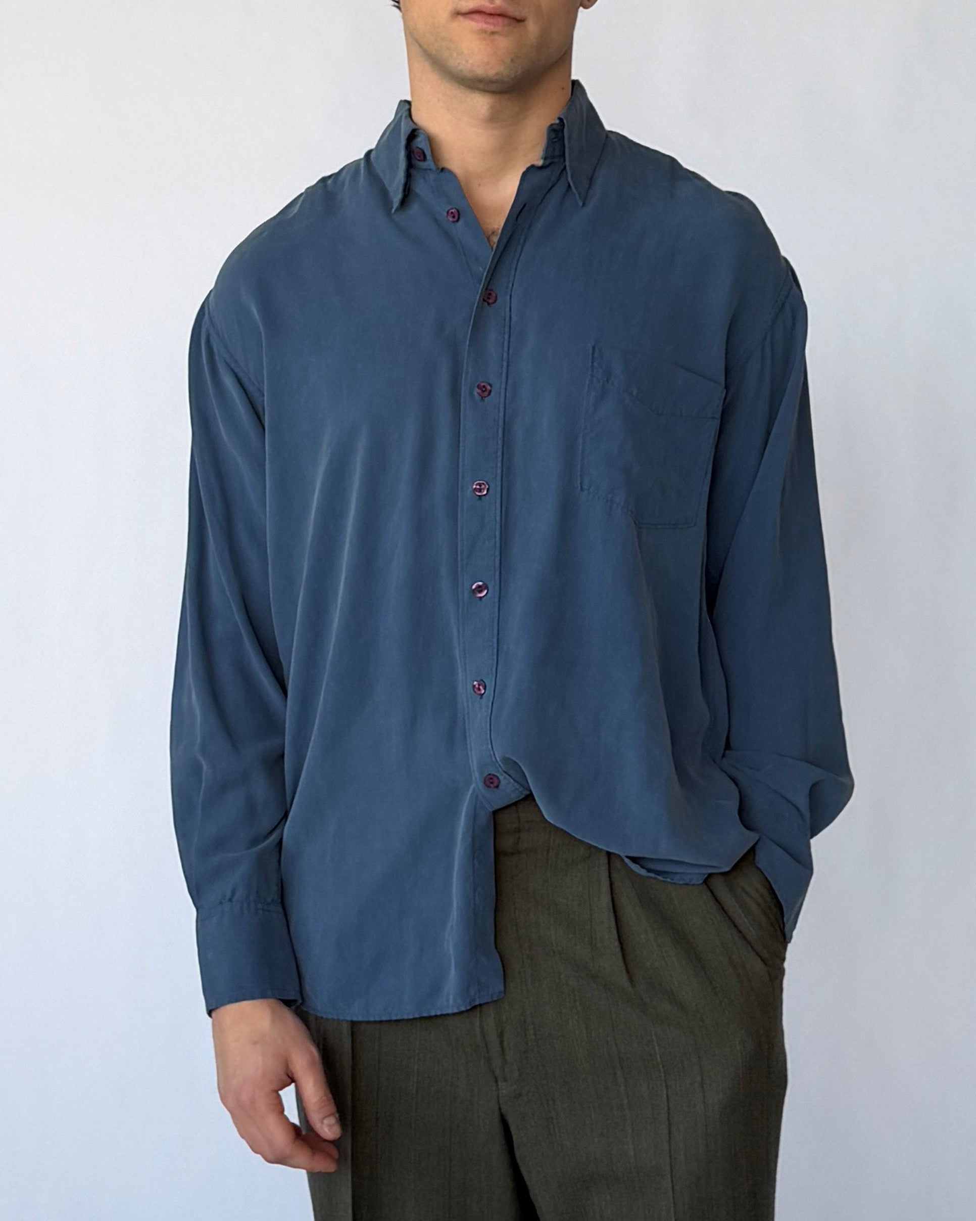 Close-up front view of vintage blue silk button-up shirt with chest pocket and buttons