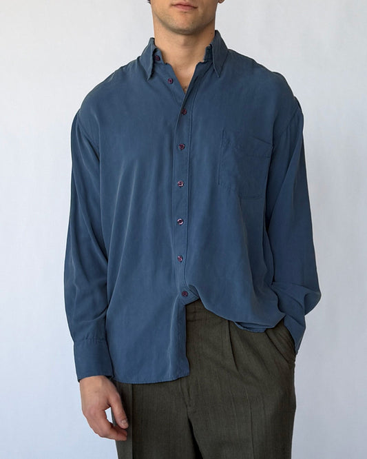 Close-up front view of vintage blue silk button-up shirt with chest pocket and buttons