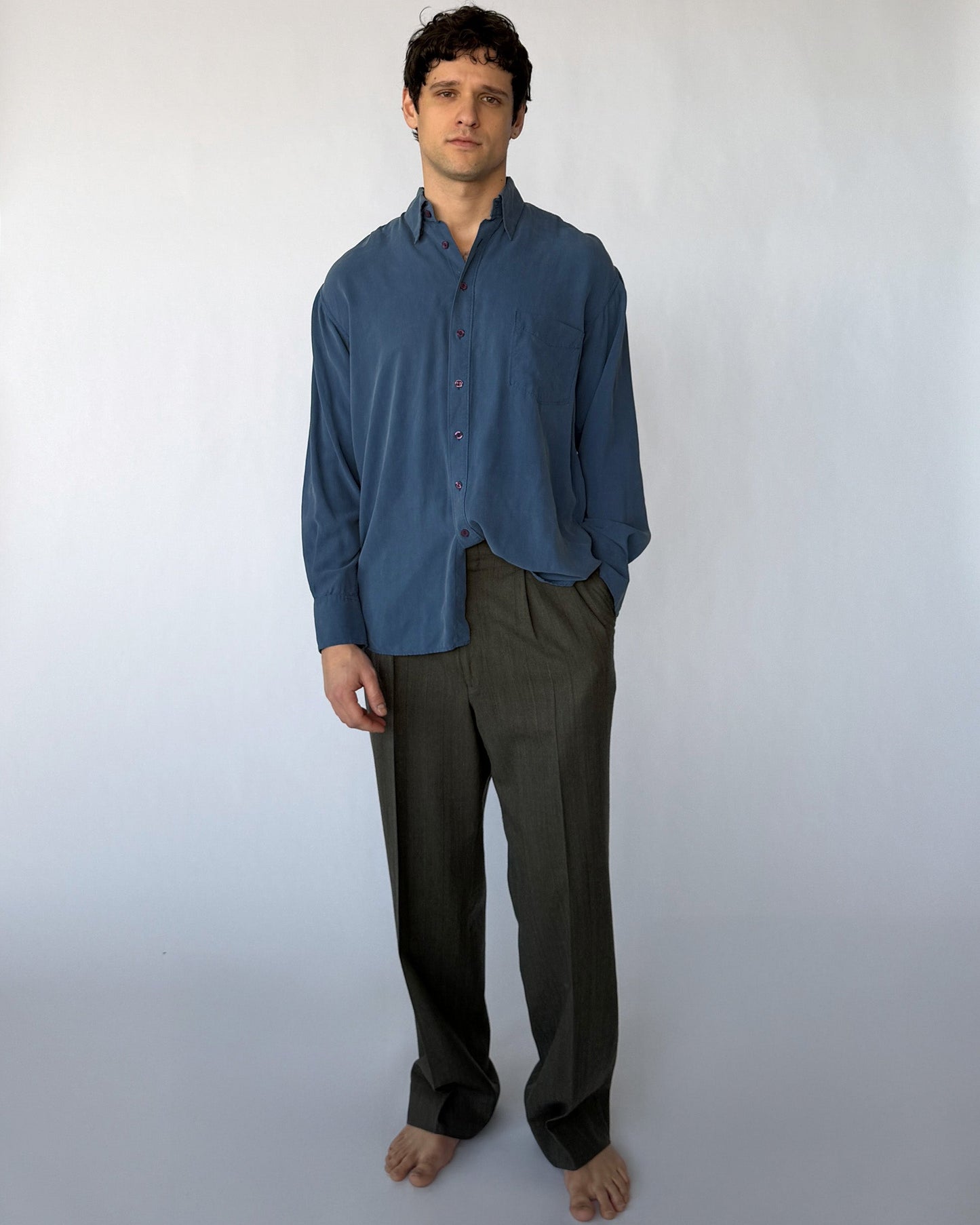 Vintage blue silk button-up shirt worn by model, relaxed fit long sleeve front view